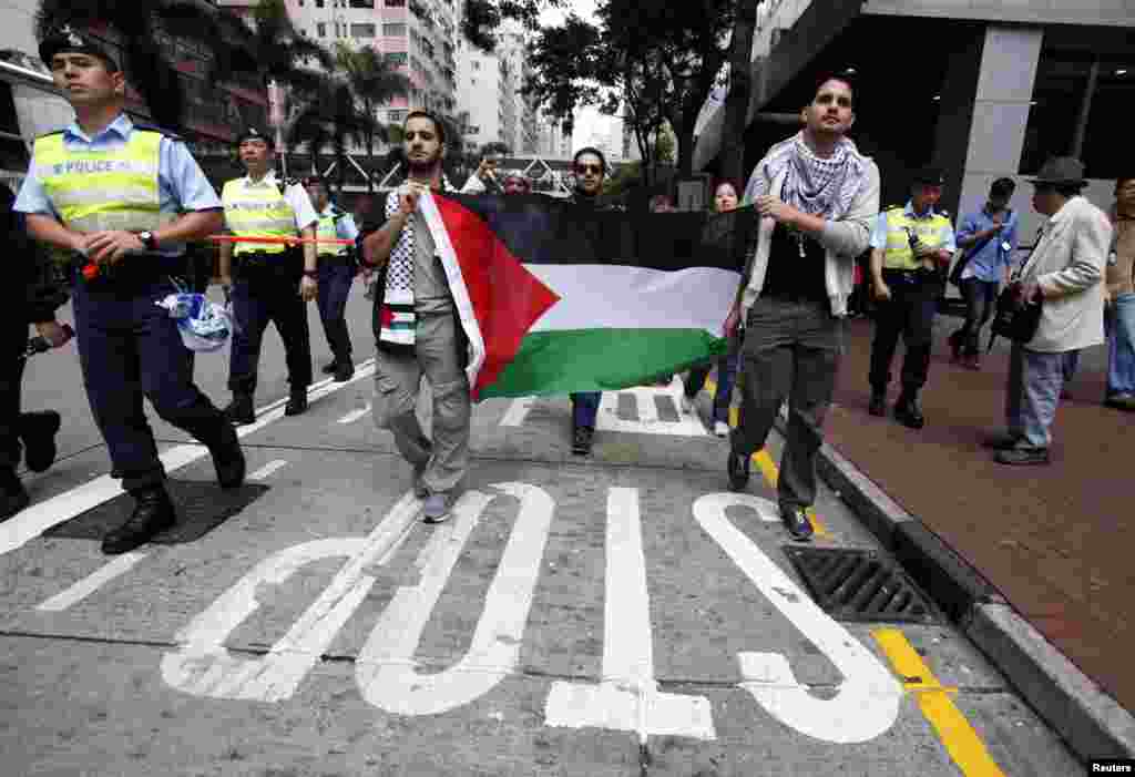  Người biểu t&igrave;nh tại Hong Kong mang theo quốc kỳ Palestine xuống đường phản đối c&aacute;c vụ n&eacute;m bom của Israel v&agrave;o Dải Gaza, ng&agrave;y 18/11/2012. 
