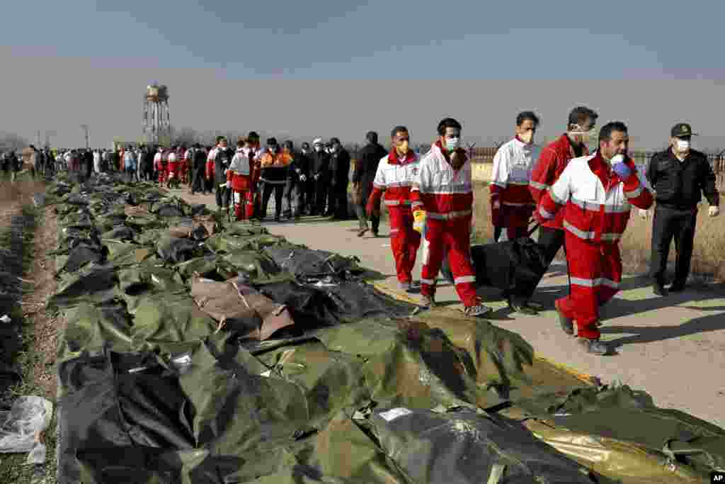 Rescue workers carry the body of a victim of a Ukrainian plane crash in Shahedshahr, southwest of the capital Tehran, Iran.