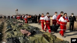 Les secouristes portent le corps d'une victime de l'accident d'avion à Shahedshahr, au sud-ouest de la capitale Téhéran, Iran, mercredi 8 janvier 2020.
