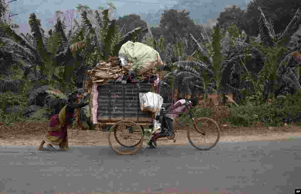 Sepasang suami-istri India mengangkut barang-barang yang bisa didaur-ulang dengan sepeda di pinggiran Gauhati.