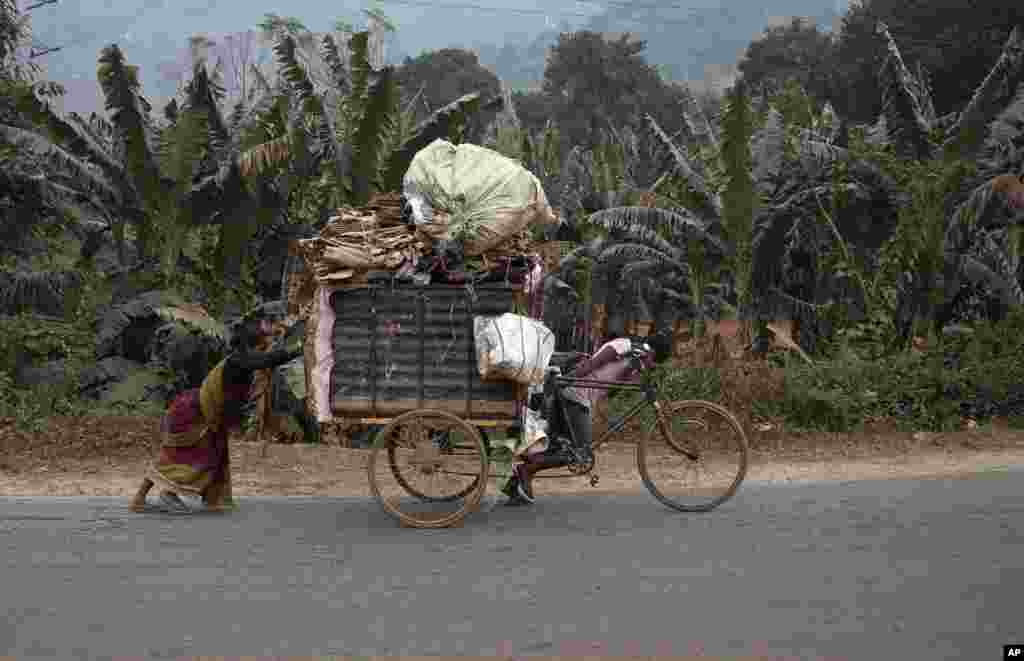 គ្រួសារ​ជន​ជាតិ​ឥណ្ឌា​មួយ​កំពុង​ដឹក​ជញ្ជូនសម្ភារៈអេតចាយ​លើ​រទេះ​ខាង​ក្រៅ​ទីក្រុង​ Gauhati។