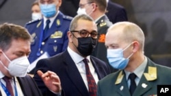 Britain's Minister for the Middle East James Cleverly, center, arrives for the NATO-Russia Council at NATO headquarters, in Brussels, Jan. 12, 2022.