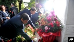 FILE - People lay flower tributes during ceremony marking first anniversary of violence between ethnic Kyrgyz and minority Uzbeks in the southern city of Osh, Kyrgyzstan, June 10, 2011.
