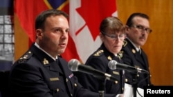 From left, James Malizia and Jennifer Strachan, both Royal Canadian Mounted Police officials, and Deputy Commissioner Scott Tod of the Ontario Provincial Police talk to reporters in Ottawa after announcing terror-related charges against three men, Feb. 3, 2015. 