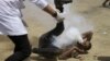 FILE - Palestinian medic rushes to a a protester who got shot in his mouth by teargas canister fired by Israeli troops near the Gaza Strip's border with Israel, east of Khan Younis, in the Gaza Strip, June 8, 2018. 