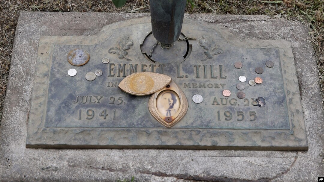 FILE - The grave marker of Emmett Till has a photo of Till and coins placed on it during a gravesite ceremony at the Burr Oak Cemetery marking the 60th anniversary of the murder of Till in Mississippi, Aug. 28, 2015, in Alsip, Ill.