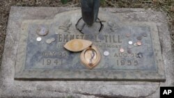 FILE - The grave marker of Emmett Till has a photo of Till and coins placed on it during a gravesite ceremony at the Burr Oak Cemetery marking the 60th anniversary of the murder of Till in Mississippi, Aug. 28, 2015, in Alsip, Ill.