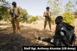 Burkinabe soldiers guard a terrorist during a simulated terrorist attack in Ouagadougou, Burkina Faso, Feb. 27, 2019, during Flintlock 2019. The Burkinabe army was responsible for cordoning off the surrounding area and securing any surviving terrorists.