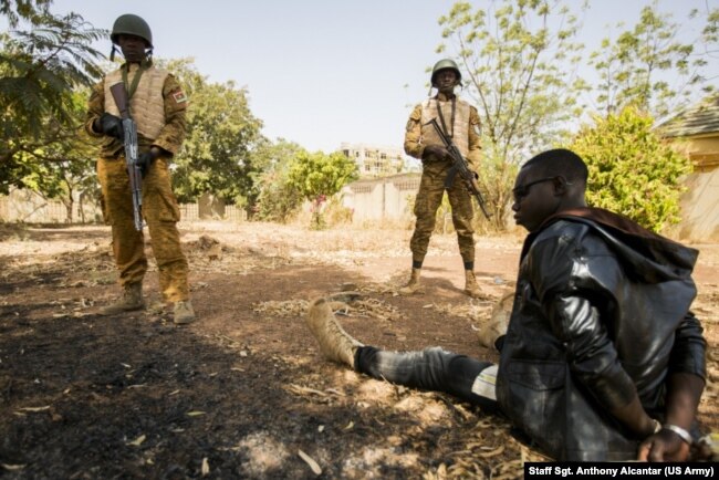 Burkinabe soldiers guard a terrorist during a simulated terrorist attack in Ouagadougou, Burkina Faso, Feb. 27, 2019, during Flintlock 2019. The Burkinabe army was responsible for cordoning off the surrounding area and securing any surviving terrorists.