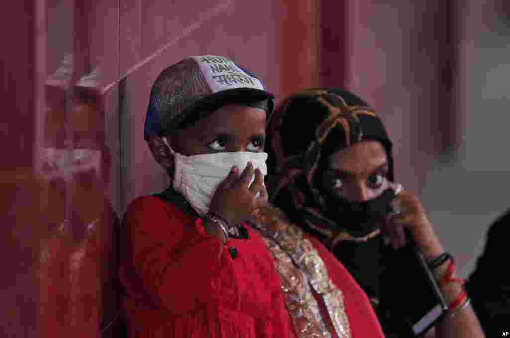 A woman and a child wait to give their nasal swab samples to test for COVID-19 at a government hospital in Unchahar, Raebareli district, Uttar Pradesh, India, Monday, Sept. 28, 2020. (AP)