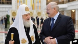 Belarusian President Alexander Lukashenko, right, and Russian Orthodox Church Patriarch Kirill walk during their meeting in Minsk, Belarus, Oct. 15, 2018. 