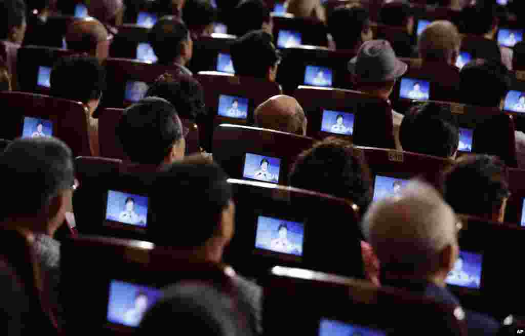 Participants listen to South Korean President Park Geun-hye&#39;s speech on small screens during a ceremony in Seoul, to mark the South Korean Liberation Day from Japanese colonial rule in 1945.