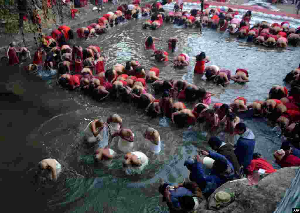 Nepalese Hindu devotees gather to bathe in the Shali River on the outskirts of Kathmandu, Nepal.