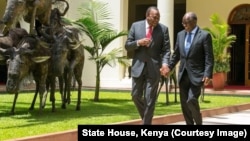 Kenyan President Uhuru Kenyatta, left, and Tanzanian counterpart John Magufuli clasp hands during Magufuli's state visit to Nairobi, Oct. 31, 2016. The two hope to strengthen their countries' economic ties.