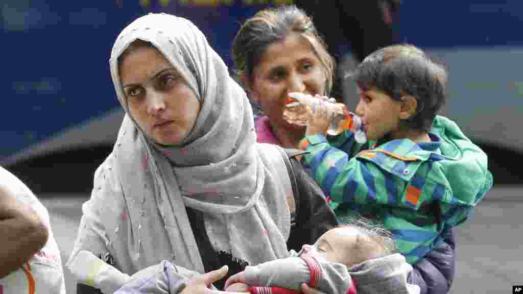 Une femme porte&nbsp;un enfant à leur arrivée à la gare principale de Munich, en Allemagne,&nbsp; 5 septembre 2015.