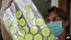 A laboratory worker tests Hungarian cucumbers for bacteria at the Food and Feed Safety Directorate of the Central Agricultural Office in Budapest June 9, 2011