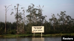 A warning sign belonging to the company Royal Dutch Shell is seen along the Nembe creek in Nigeria's oil state of Bayelsa, December 2, 2012 file photo. 