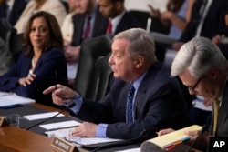 Sen. Dick Durbin, D-Ill., flanked by Sen. Kamala Harris, D-Calif., left, and Sen. Sheldon Whitehouse, D-R.I., questions witnesses as the Senate Judiciary Committee holds a hearing on the Trump administration's policies on immigration enforcement and family reunification efforts, on Capitol Hill in Washington, July 31, 2018.