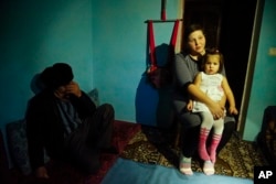 FILE - Elnara, the wife of arrested Tatar protester Ali Asanov, is seen with one of her daughters in their home in Urozhayne, Crimea, Jan. 24, 2016. Russian authorities have used arrests as part of an intimidation campaign against local Tatars, rights advocates say.