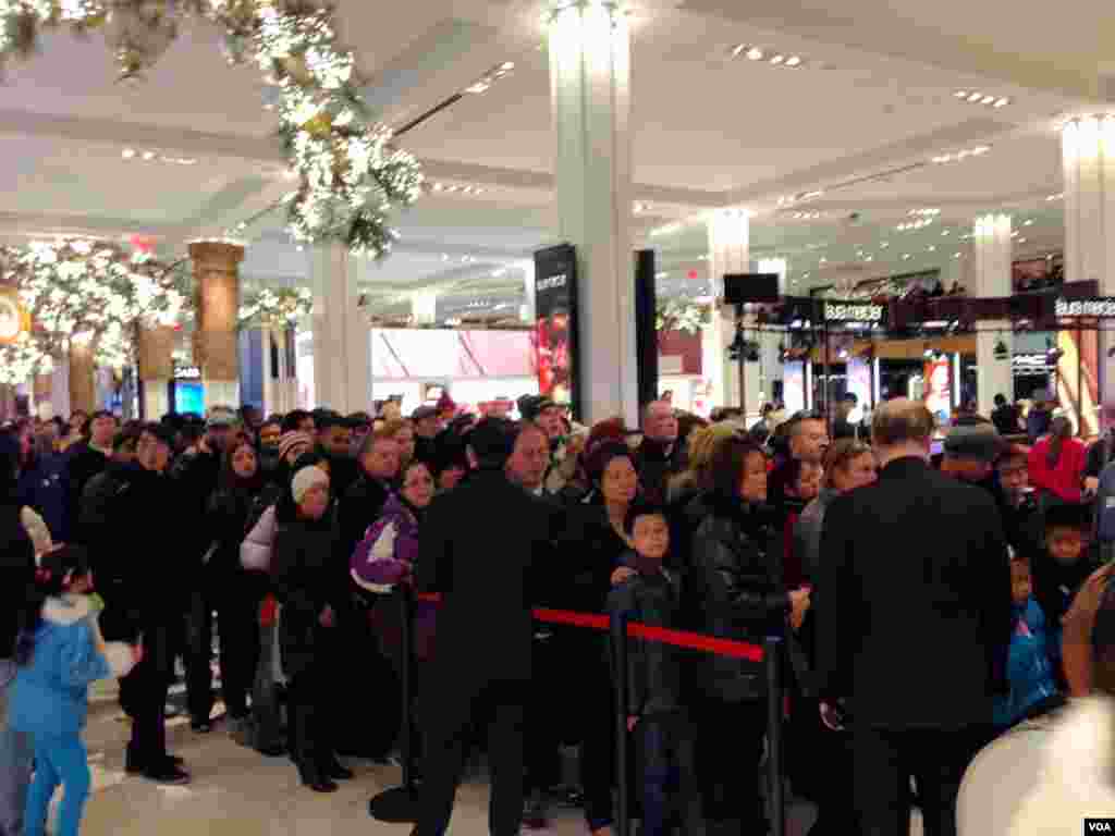 Shoppers line up to get on the escalator at Macy's Herald Square in New York on Thanksgiving, Nov. 28, 2013. (Sandra Lemaire/VOA)