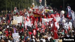 Demonstrators carry banners as they march to Madrid's Colon Square during a protest against government's cost-cutting measures, September 15, 2012.