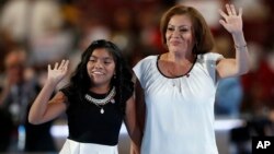Karla Ortiz, de 11 años, y su madre, Francisca, saludan a la Convención Demócrata en Filadelfia.