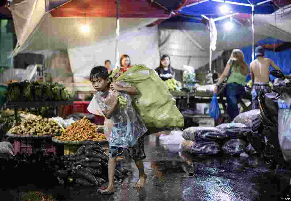 필리핀 마닐라의 디비소리아시장에서 한 소년이 자신이 모은 재활용 병들을 포대에 넣어 고물상에 팔러 가고 있다.