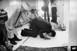 FILE - Then-U.S. heavyweight boxing champ Muhammad Ali prays at a mosque during his 12-day visit to the Soviet Union in June 1978.
