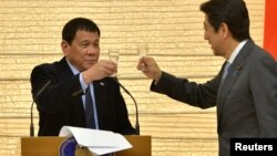 FILE - Philippines President Rodrigo Duterte (L) toasts with Japan Prime Minister Shinzo Abe during a banquet at Abe's official residence in Tokyo, Oct. 26, 2016. 