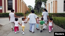 Children walk with social workers at the Puericultorio Perez Aranibar children's home in Lima, Peru, March 9, 2012. 
