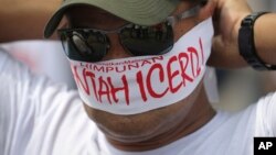 A protester covers his face with headbands reading "No to ICERD" during a rally to celebrate the government's decision not to ratify a U.N. anti-discrimination convention called ICERD at Independent Square in Kuala Lumpur, Malaysia, Dec. 8, 2018. ICERD stands for International Convention on the Elimination of All Forms of Racial Discrimination.