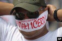 A protester covers his face with headbands reading "No to ICERD" during a rally to celebrate the government's decision not to ratify a U.N. anti-discrimination convention called ICERD at Independent Square in Kuala Lumpur, Malaysia, Dec. 8, 2018. ICERD stands for International Convention on the Elimination of All Forms of Racial Discrimination.