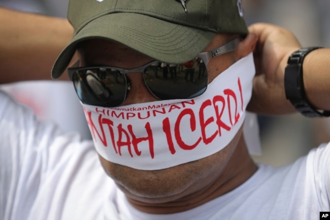 A protester covers his face with headbands reading "No to ICERD" during a rally to celebrate the government's decision not to ratify a U.N. anti-discrimination convention called ICERD at Independent Square in Kuala Lumpur, Malaysia, Dec. 8, 2018. ICERD stands for International Convention on the Elimination of All Forms of Racial Discrimination.