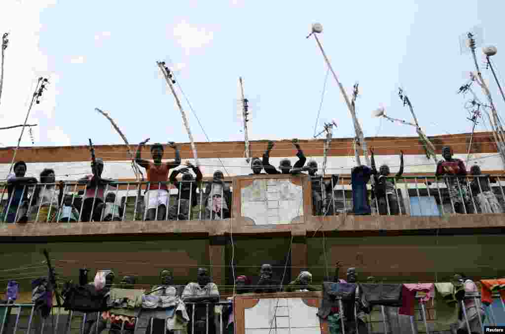 Supporters of Kenyan Prime Minister Raila Odinga look out from the balconies of a building in the Mathare slum in Nairobi, Mar. 9, 2013. 