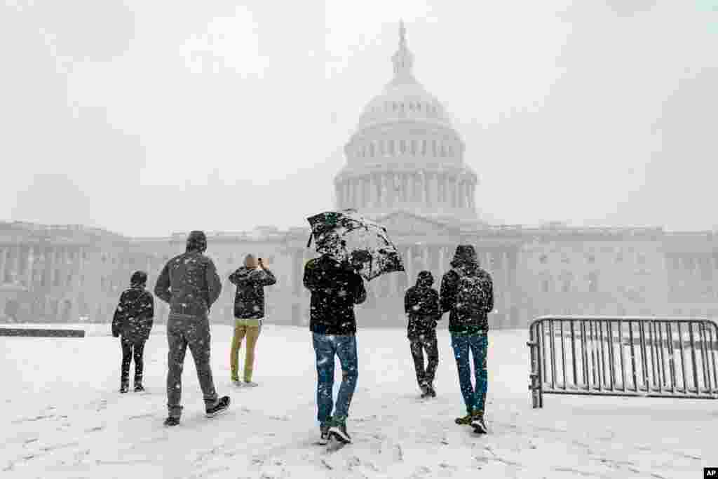 Visitors from France enjoy the scenery during a winter storm on the Capitol Hill in Washington.