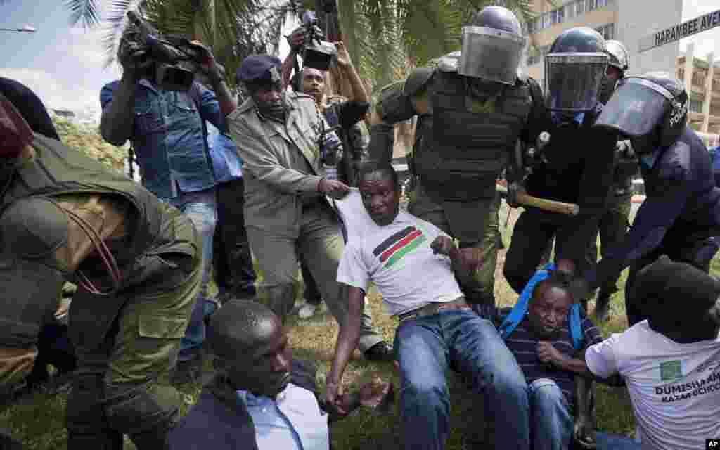 Protesters against the new security law are arrested by riot police after shouting against the new law, outside the Parliament building in Nairobi, Kenya Thursday, Dec. 18, 2014.
