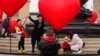 FILE - Families with young children pose for photos in Beijing, China, Feb. 13, 2021. Struggling with an aging population and declining birth rates, China is trying to shift its population policies to avert a demographic crisis.