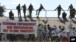 Zimbabwean soldiers look on as Zanu PF youths march for President Robert Mugabe at a rally in Bulawayo, June 20, 2008. 