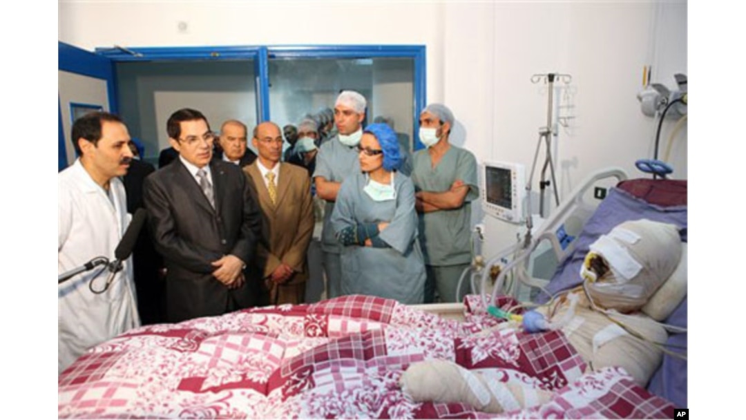In this photo released 28 Dec 2010 by the Tunisian President's office, Tunisia's President Zine El Abidine Ben Ali, 2nd left, visits Mohamed Bouazizi, a young man who set himself on fire after police confiscated fruit and vegetables he sold without a perm