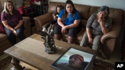Family members of Jerry Ramos become emotional when looking at a photo of him at the family home in Watsonville, Calif., Sunday, June 6, 2021. (AP Photo/Nic Coury)
