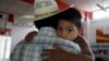 FILE - Miguel, 3, clings to his father, Miguel, an undocumented migrant, in San Juan, Texas, Aug. 27, 2010. Miguel and his wife, who remain in the U.S. as undocumented migrants, have two children born in the U.S. 