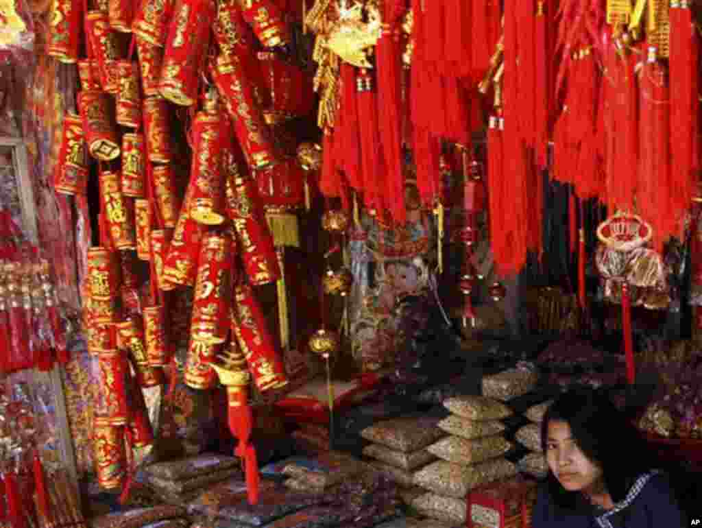 In this photo taken Saturday, Jan. 7, 2012, a Myanmar girl waits for customers at a shop selling Chinese New Year decorations for the upcoming Chinese New Year in Yangon, Myanmar. (AP Photo/Apichart Weerawong)