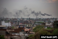 FILE - Smoke rises from chimneys of leather tanneries in Kanpur, an industrial city on the banks of the river Ganges, India, Tuesday, June 23, 2020. (AP Photo/Altaf Qadri)