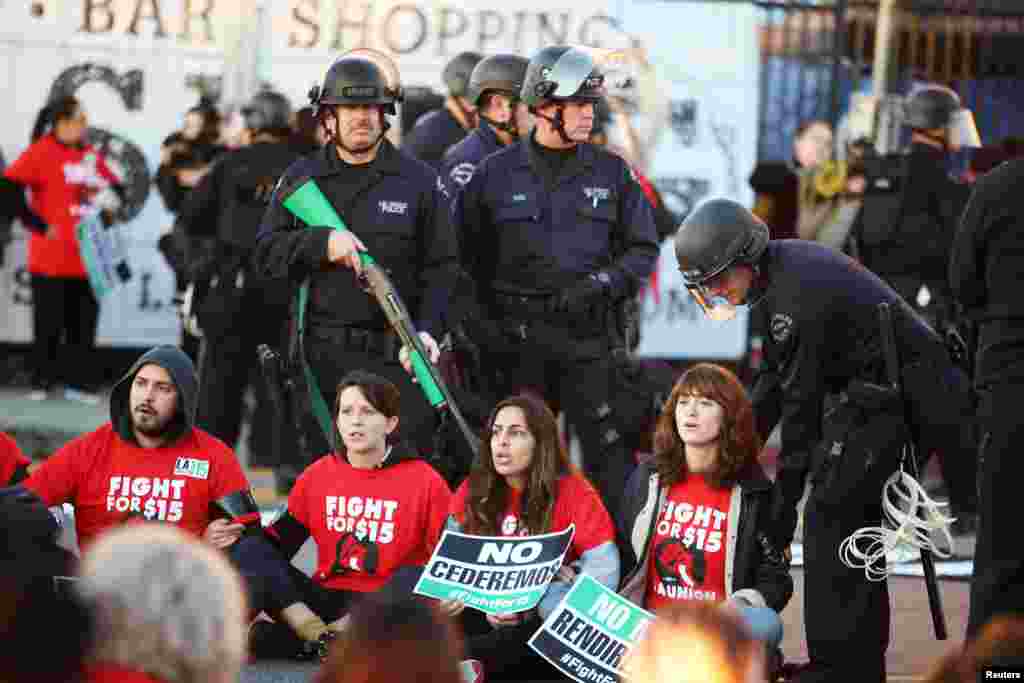 پلیس ضد شورش در جریان یک تجمع در لس آنجلس. معترضان خواستار حداقل دستمزد ۱۵ دلار در ساعت هستند.