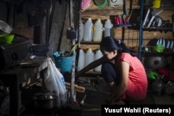 Seorang gadis yang menikah di bawah umur pada Maret 2020, sedang memasak di dapurnya di Botteng Utara di Mamuju, Sulawesi Barat. (Foto: AFP/Yusuf Wahil)