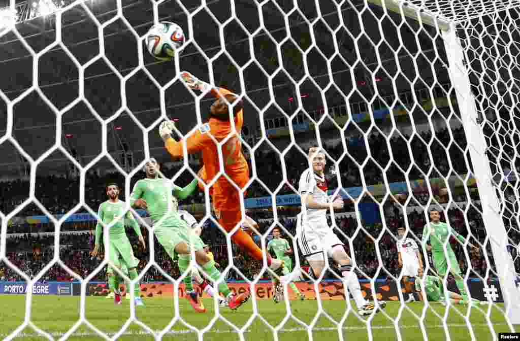 German Andre Schuerrle scores past Algerian goalkeeper Rais Mbolhi in extra time at the Beira Rio stadium, in Porto Alegre, June 30, 2014.