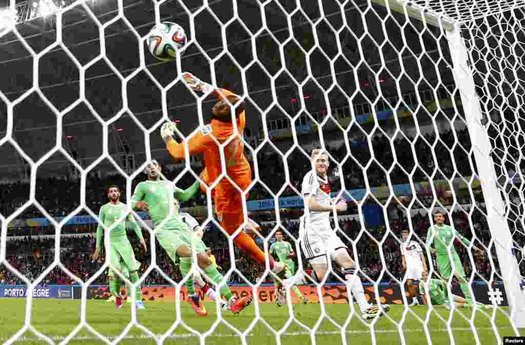 Pemain Jerman Andre Schuerrle memberikan angka setelah membobol gawang Aljazair yang dijaga oleh kiper Rais Mbolhi dalam perpanjangan waktu di stadion Beira Rio di Porto Alegre, 30 Juni 2014.