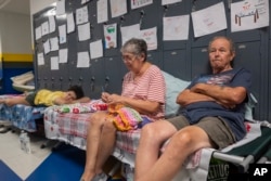 Gordon y Dina Reynolds con su nieta de 11 años, Abby, esperan en un refugio de la escuela secundaria North Myrtle Beach, convertida en refugio de la Cruz Roja para evacuados del huracán Dorian. Septiembre 4 de 2019.