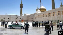 FILE - Police officers patrol the scene, around the shrine of late Iranian revolutionary founder Ayatollah Khomeini, after an attack claimed by the Islamic State group, in Tehran, Iran, June 7, 2017.