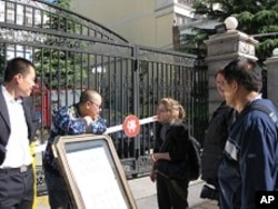 Plain clothes security agents refuse to let any reporter into the residential Beijing compound where Liu Xia, the wife of the newest Nobel Peace Laureate Liu Xiaobo, lives.